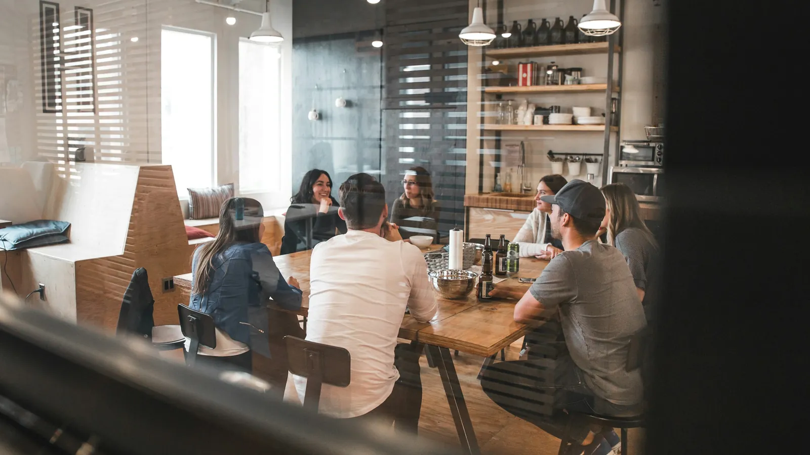 Equipo de trabajo conversando alrededor de una mesa en una oficina luminosa